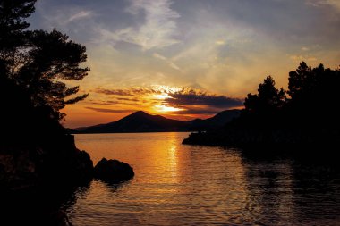 İnanılmaz bir manzara. Dağların arka planında gün batımı 