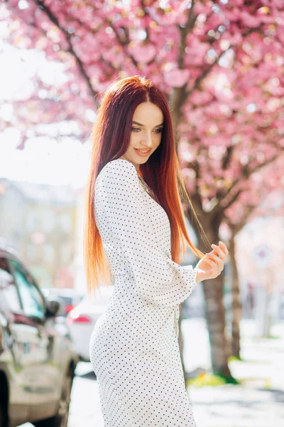一个红头发的年轻女子的画像 背景是盛开的春葵 — 图库照片