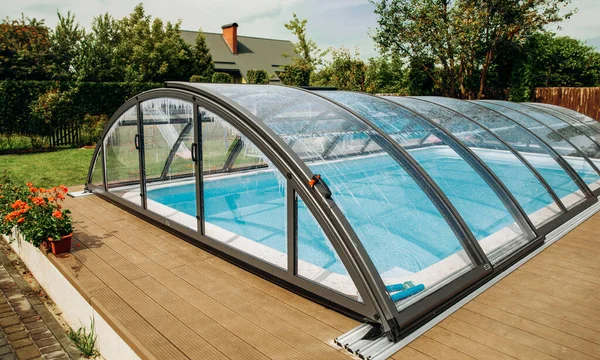 Polycarbonate Cover. Outdoor swimming pool with automatic pool cover in the garden.