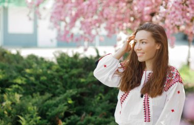 Çiçek parkında pembe çiçeklerle güzel bir kadının romantik portresi.