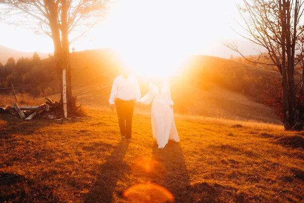 山の中で晴れた日に手を携えて結婚式のカップルは エレガントな結婚式の衣装を着て 冒険と美しい生活の概念 — ストック写真