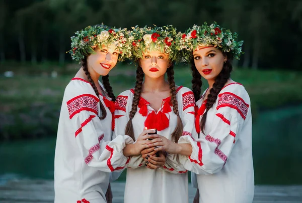 Akşamları ellerinde fenerle gölün kenarında pagan genç kızlar. Yaz kutlamaları Kupala