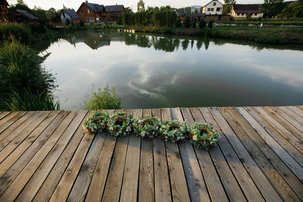 Braided wreaths lie on the river pier. Traditional celebration of Kupala