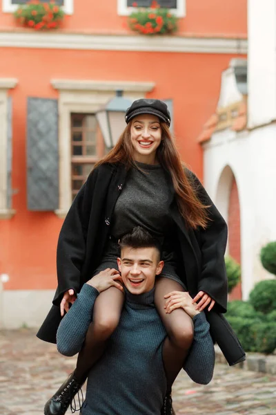 Komik kız oğlanın boynuna oturur. Mutlu çift eğleniyor, bahçede yürüyor..