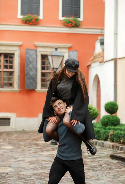 Komik kız oğlanın boynuna oturur. Mutlu çift eğleniyor, bahçede yürüyor..