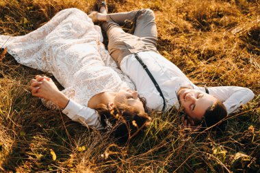 Beautiful newlyweds walking in the mountains. Wedding in boho style.