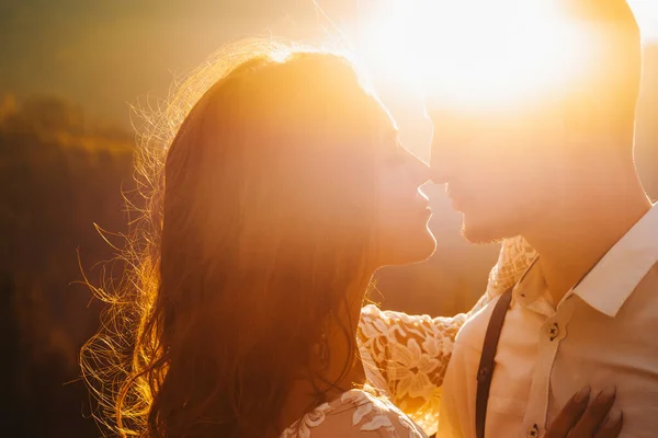 A boho wedding in the mountains. Close-up portrait of beautiful newlyweds at sunset