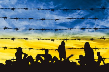 Ukraynalı mülteciler bir mülteci kampında, dikenli tellerin yanında gökyüzüne karşı Ukrayna bayrağı şeklinde. Ukraynalı mülteci kavramı. Rusya ile Ukrayna 'da Savaş ve Kriz