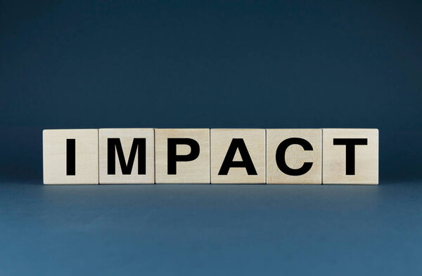 Impact. Cubes form the word Impact. The concept of Impact in business and other fields