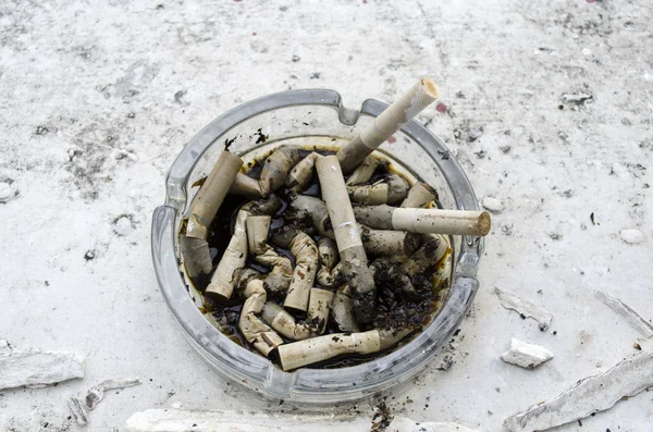 Cenicero lleno de cigarrillos colillas quemadas — Foto de Stock