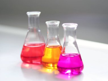 Erlenmeyer ya da konik matara göğüs laboratuarında, titre deneyinden renkli çözücü ile birlikte. Asitlik ve alkalite parametresi, atık su örneğinde bileşik asit baz analizi..