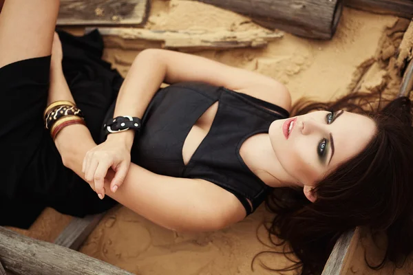 Fashion girl lying on the sand desert. — Stock Photo, Image