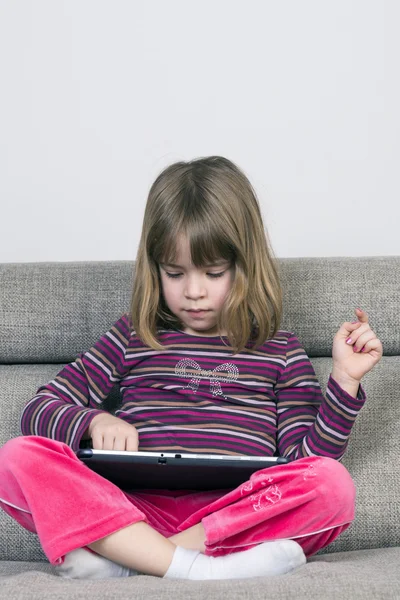 Kleines Mädchen spielt mit digitalem Tablet — Stockfoto