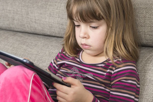 Klein meisje spelen met een digitale tablet — Stockfoto