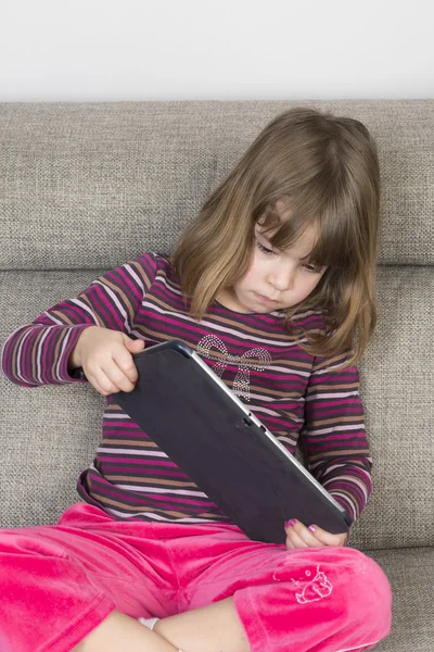 Kleines Mädchen spielt mit digitalem Tablet — Stockfoto