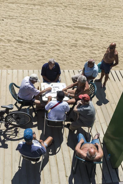 Personas mayores jugando dominó en la playa, Barcelona . — Foto de Stock