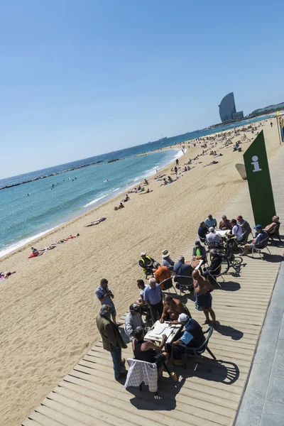 Vysocí lidé hrají domino na pláži, barcelona. — Stock fotografie