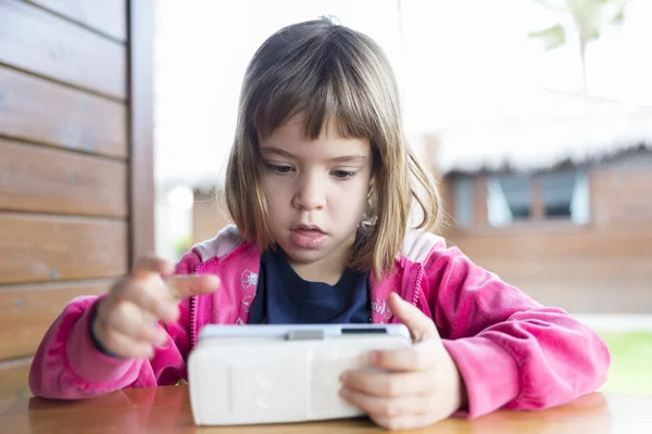 Klein meisje met een smartphone — Stockfoto