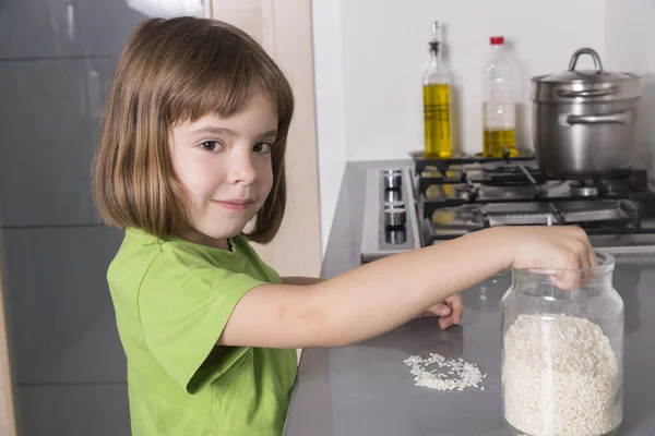 Chica poniendo arroz en un recipiente de vidrio —  Fotos de Stock