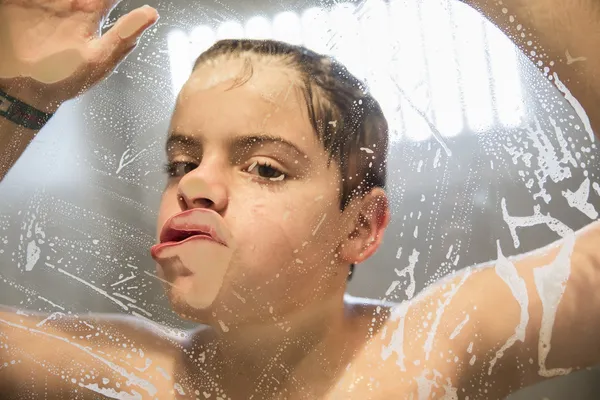 シャワーで遊んでいる若い少年 — ストック写真