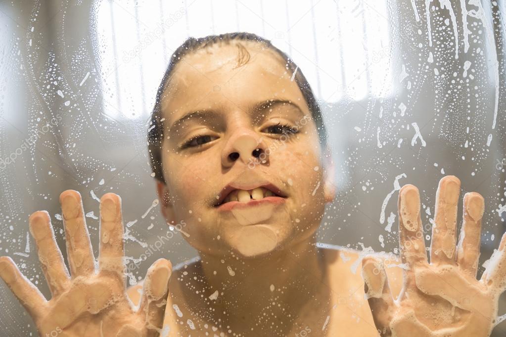 Young boy playing in the shower