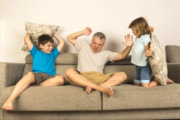 Papà e bambini litigano insieme con i cuscini — Foto Stock