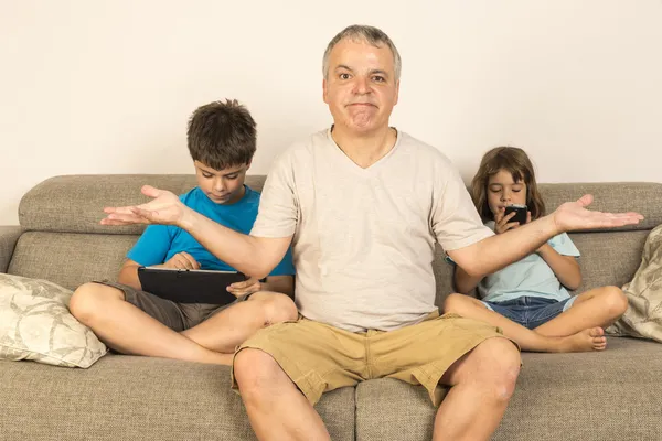 Pai e filhos sentados no sofá — Fotografia de Stock