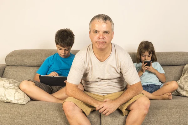 Pai e filhos sentados no sofá — Fotografia de Stock