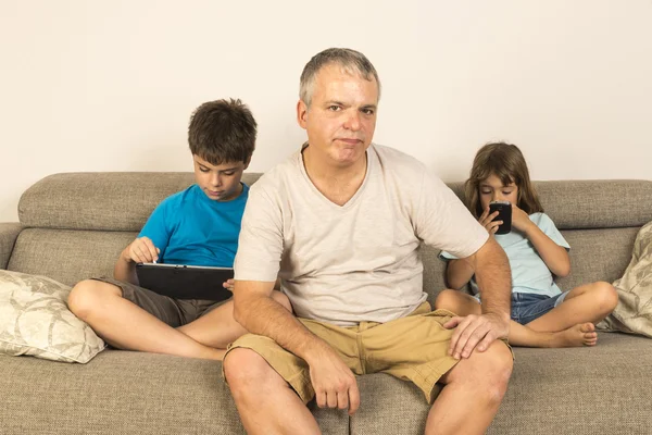 Otec i děti sedí na pohovce — Stock fotografie