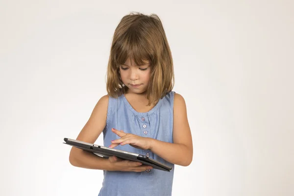 Девочка играет с цифровым планшетом — стоковое фото