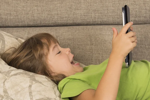 Klein meisje spelen met een digitale tablet — Stockfoto