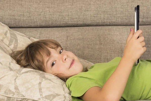 Kleines Mädchen spielt mit digitalem Tablet — Stockfoto