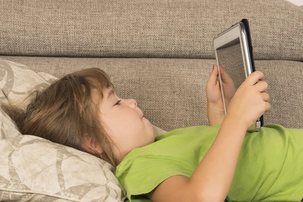 Kleines Mädchen spielt mit digitalem Tablet — Stockfoto