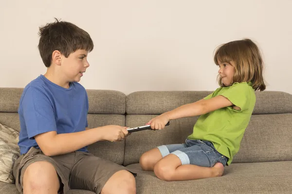 Kids arguing for playing with a digital tablet on a sofa. — Stock Photo, Image