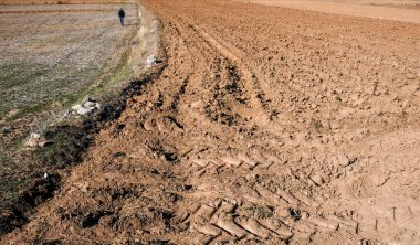 Çiftçi yeni sürülmüş tarlada yürüyor. Yeni dünyada tarım ve tarım arazisi. Dünya açlığı ve ekili tarım ürünleri. Seçici odaklanma. Sadece bir ağaç..