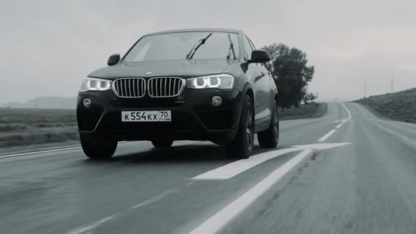 ALTAI, RUSSLAND - 29. JUNI 2021: Schwarzer BMW X4 fährt über die Autobahn. Frontansicht aus nächster Nähe — Stockvideo