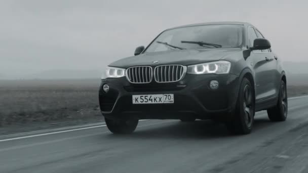 アルタイ、ロシア- 2021年6月29日:黒いBMW X4が高速道路を運転する。遅いモーメントを閉じます — ストック動画