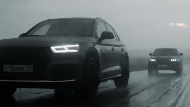 ALTAI, RUSSIE - 29 JUIN 2021 : Audi Q5 et BMW X4 roulent sur l'autoroute sous la pluie. Noir et blanc — Video