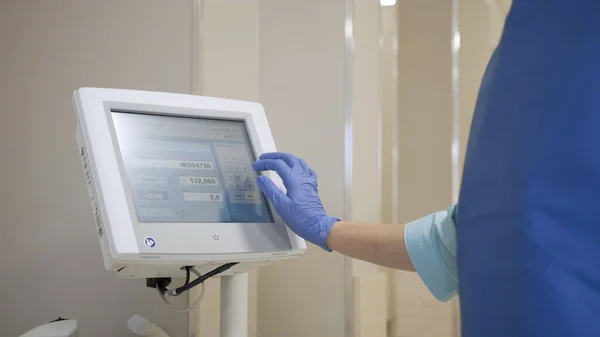Menina médico dirige dados em uma máquina para dosagem de radiação — Fotografia de Stock