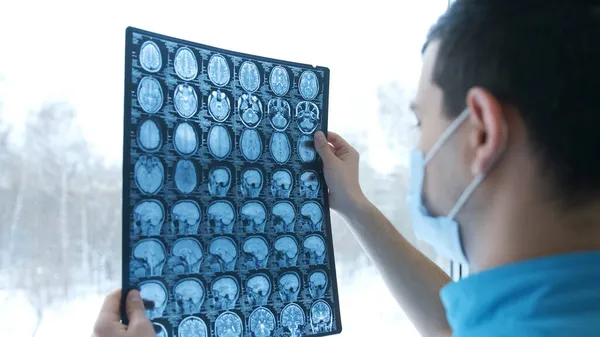 Doktor beyin MR taramalarına bakıyor.