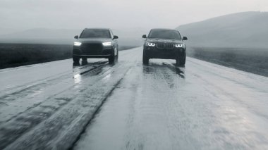 ALTAI, RUSSIA - 29 Haziran 2021: BMW X4 yağmurda otoyolda Audi Q5 'i geçti