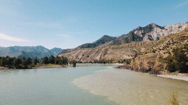 İki nehir, inanılmaz dağ manzaralı bir nehre çarpışıyor. İnsansız hava aracı görüntüleri