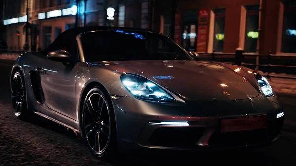 PETERSBURG, RUSSIA - 12 ARALIK 2020: güzel bir şehrin sokaklarında gümüşten Porsche 718 Boxter geziyor. Parlak farlar