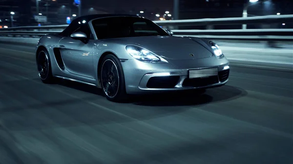 PETERSBURG, RUSSIA - 12 ARALIK 2020: güzel bir şehrin sokaklarında gümüşten Porsche 718 Boxter geziyor. Parlak farlar
