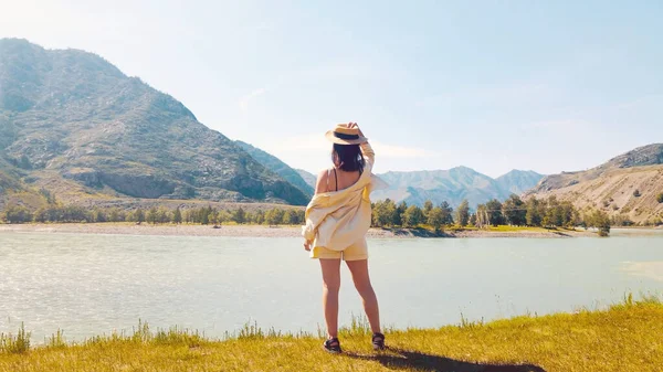 Ragazza vestita di beige sulla collina guardando oltre alla splendida vista sulle montagne. Filmati dei droni — Foto Stock