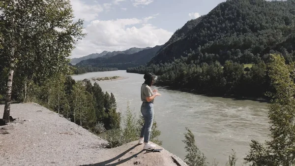 少女は手を上げて夏にアルタイの川の景色を開きます. — ストック写真