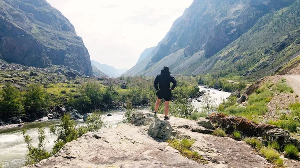 一个身穿黑色风衣的男人站在悬崖边上。Katu-Yaryk峡谷Chulyshman山谷。阿尔泰 — 图库照片
