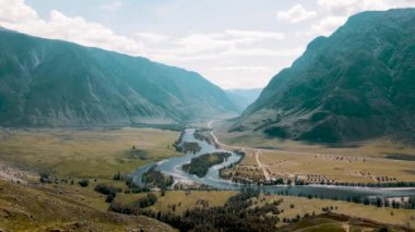 Dağların ve nehrin güzel manzarası. Evleri olan ovalar. Altai, yaz. İnsansız hava aracı görüntüleri