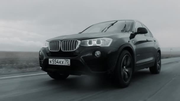 ALTAI, RUSSLAND - 29. JUNI 2021: Schwarzer BMW X4 fährt über die Autobahn. FRONT BOTTOM Ansicht — Stockvideo