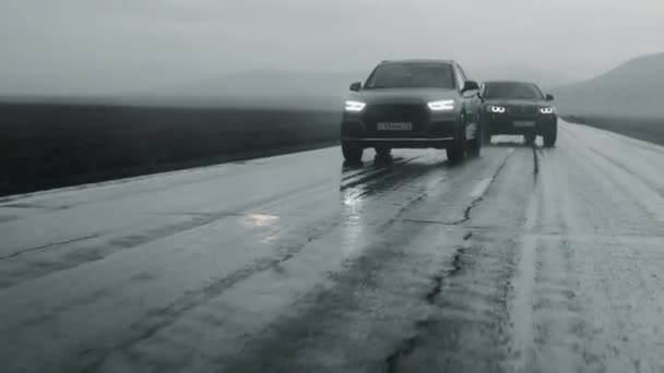ALTAI, RUSSIA - 29 CZERWCA 2021: Dwa luksusowe samochody poruszają się autostradą podczas deszczu — Wideo stockowe